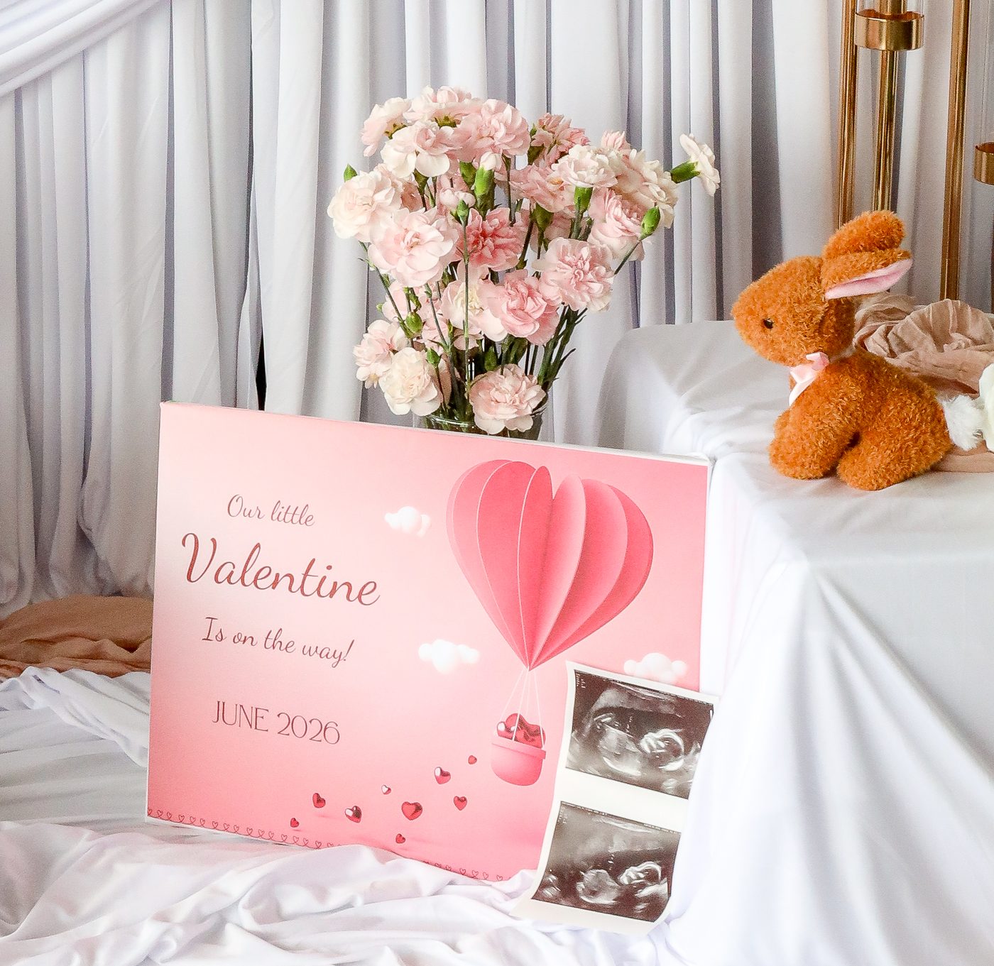 Valentine announcement sign with flowers and a plush bunny