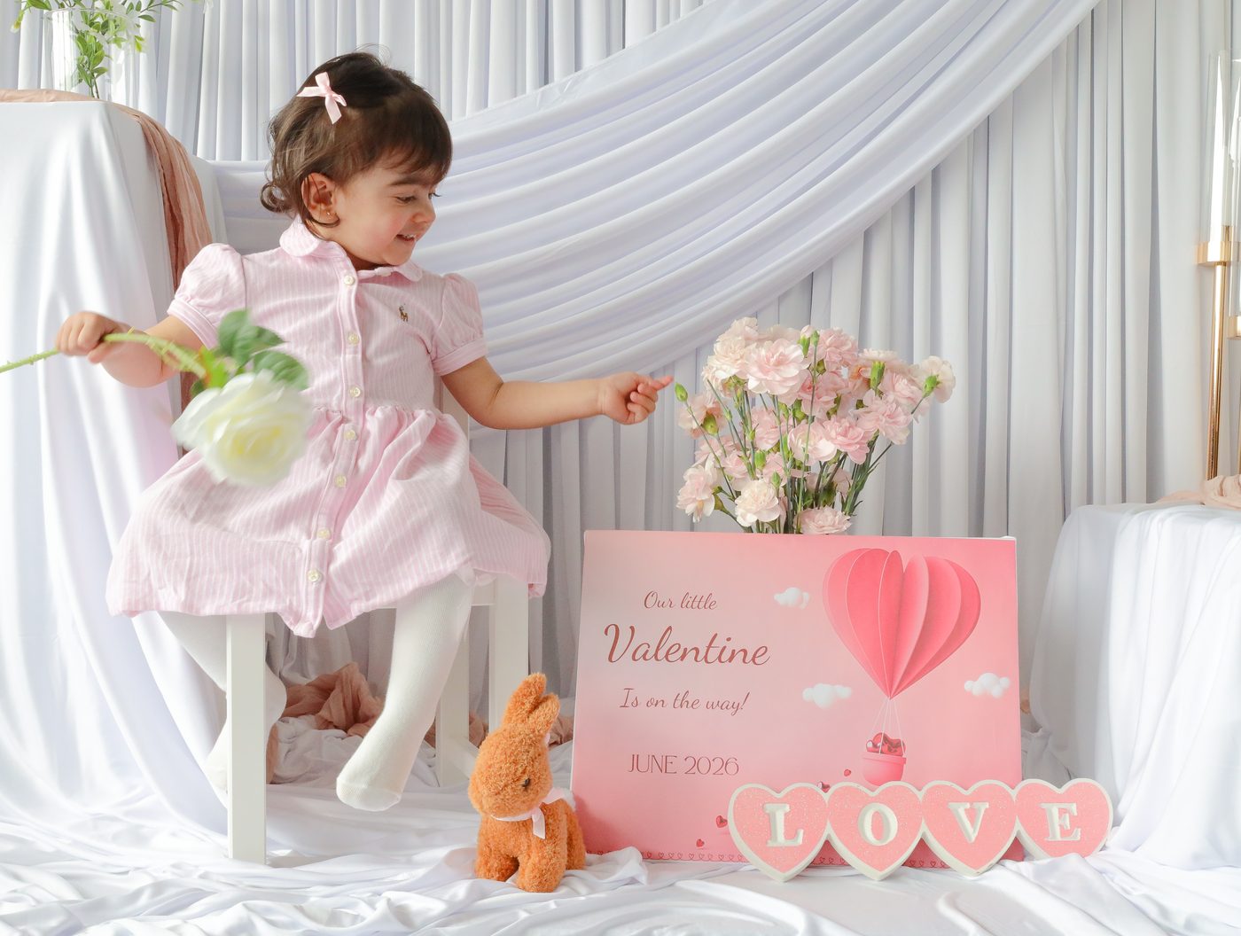 Little girl playing beside the Valentine announcement sign